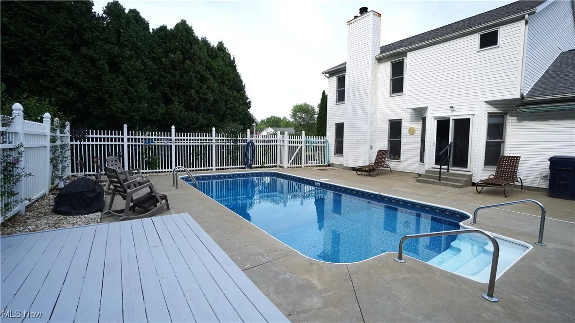 View of pool with entry steps, a patio area, and a fenced backyard