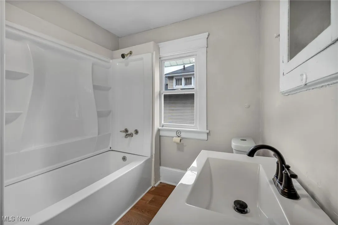 Bathroom with wood finished floors and tub / shower combination
