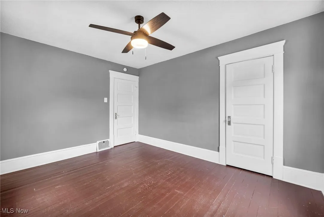 Spare room with wood-type flooring and ceiling fan