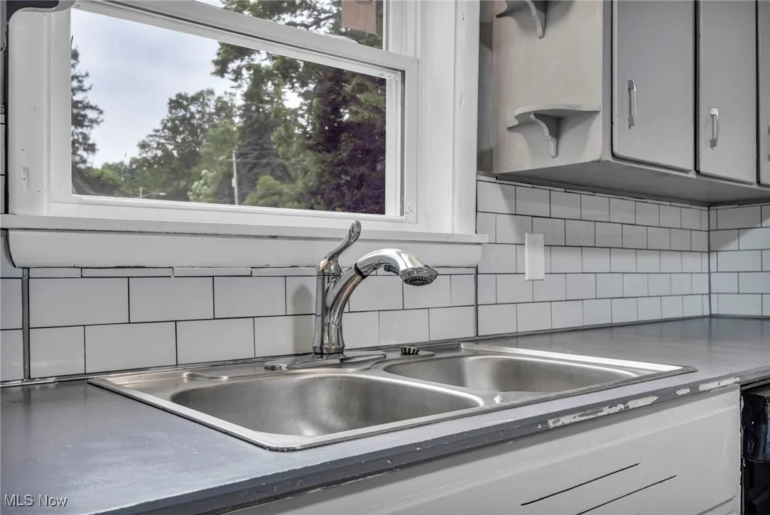 Kitchen featuring stainless steel counters and tasteful backsplash