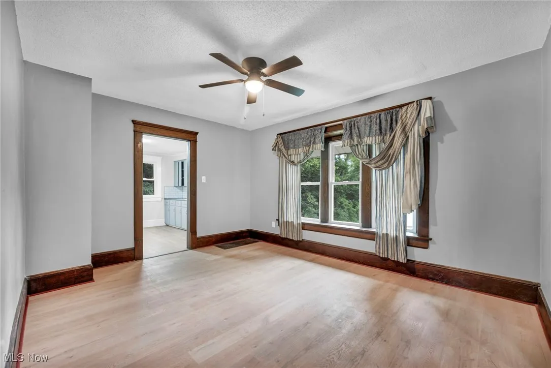 Empty room featuring wood finished floors, a textured ceiling, and ceiling fan