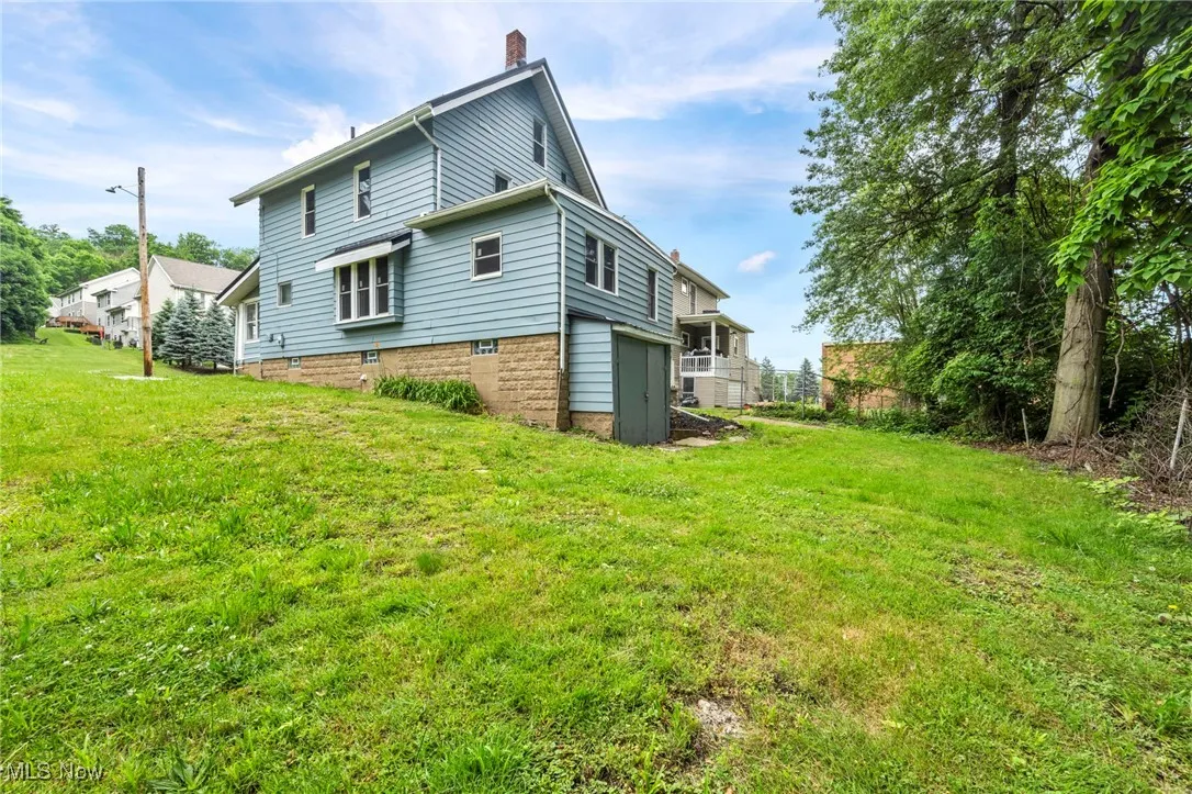 Back of house featuring a yard and a chimney