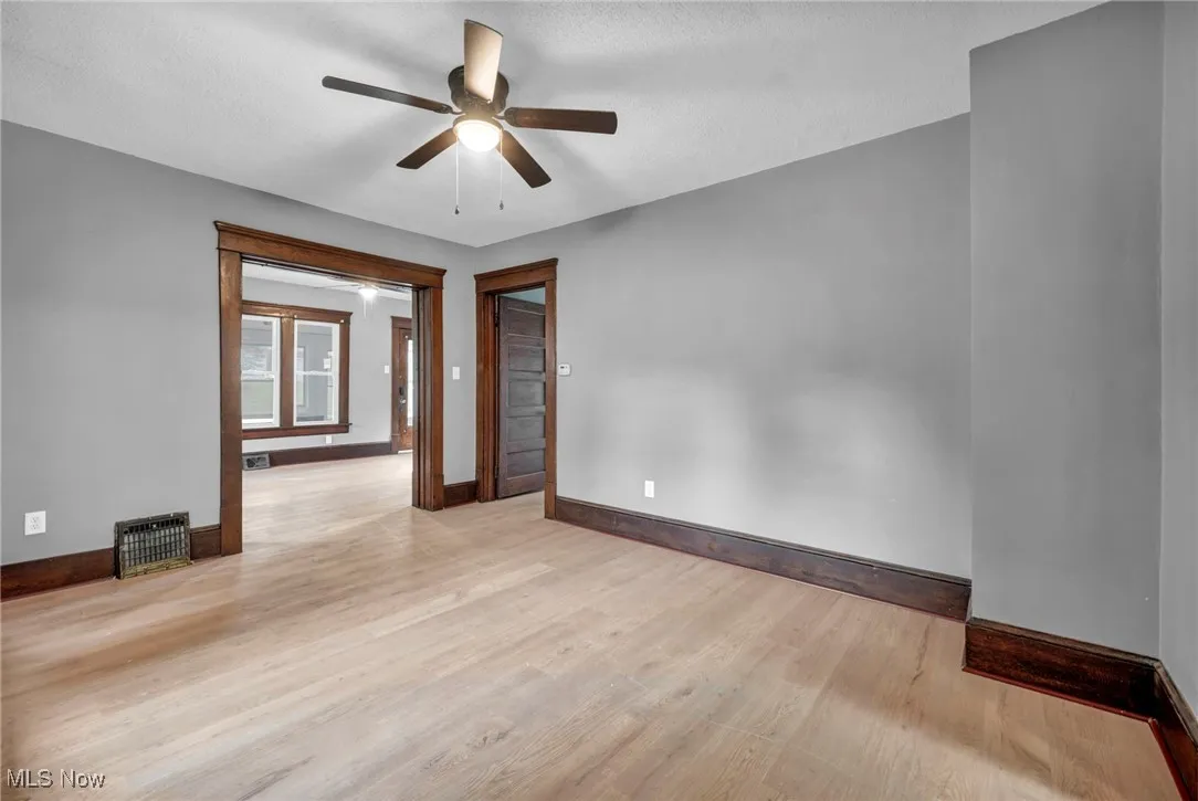 Spare room with light wood-style flooring, a ceiling fan, and a textured ceiling
