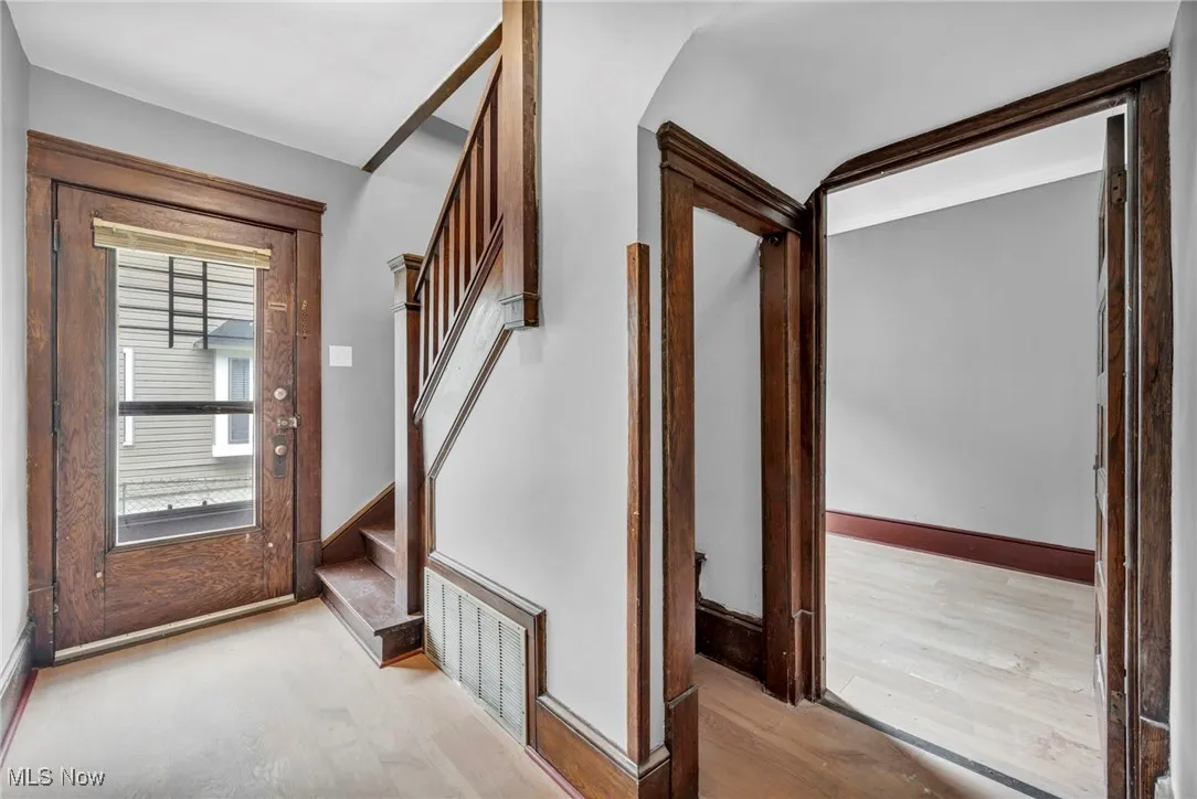 Entryway with wood finished floors and stairway