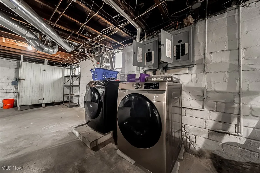 Washroom featuring independent washer and dryer and electric panel