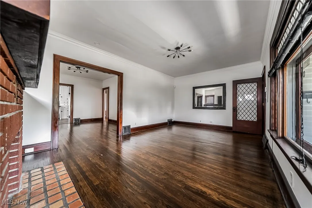 Unfurnished room with ornamental molding and wood finished floors