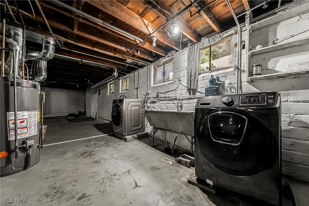Basement with gas water heater, washing machine and dryer, and plenty of natural light