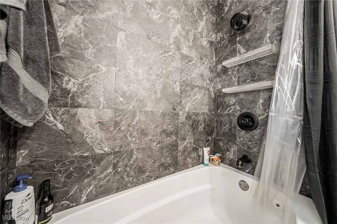 Bathroom featuring shower / bath combination with curtain
