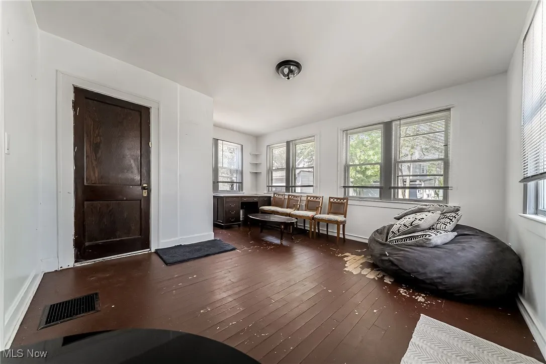 Sitting room featuring dark wood finished floors, plenty of natural light, and a baseboard heating unit