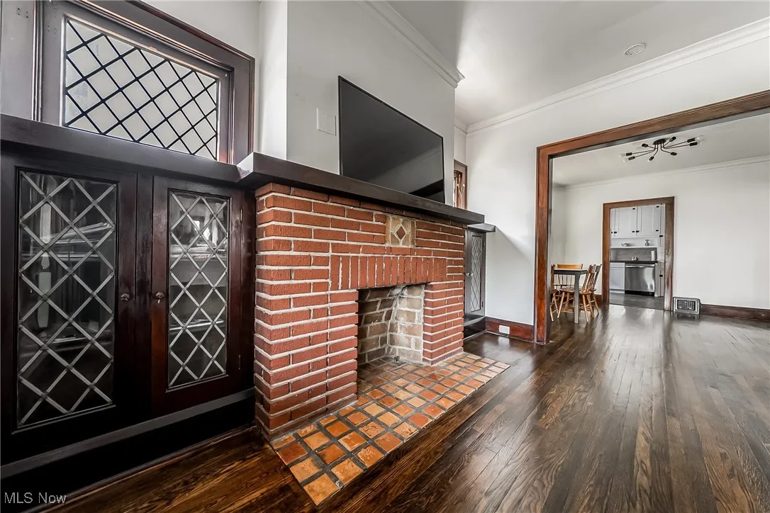 Unfurnished living room with crown molding, hardwood / wood-style floors, and a fireplace