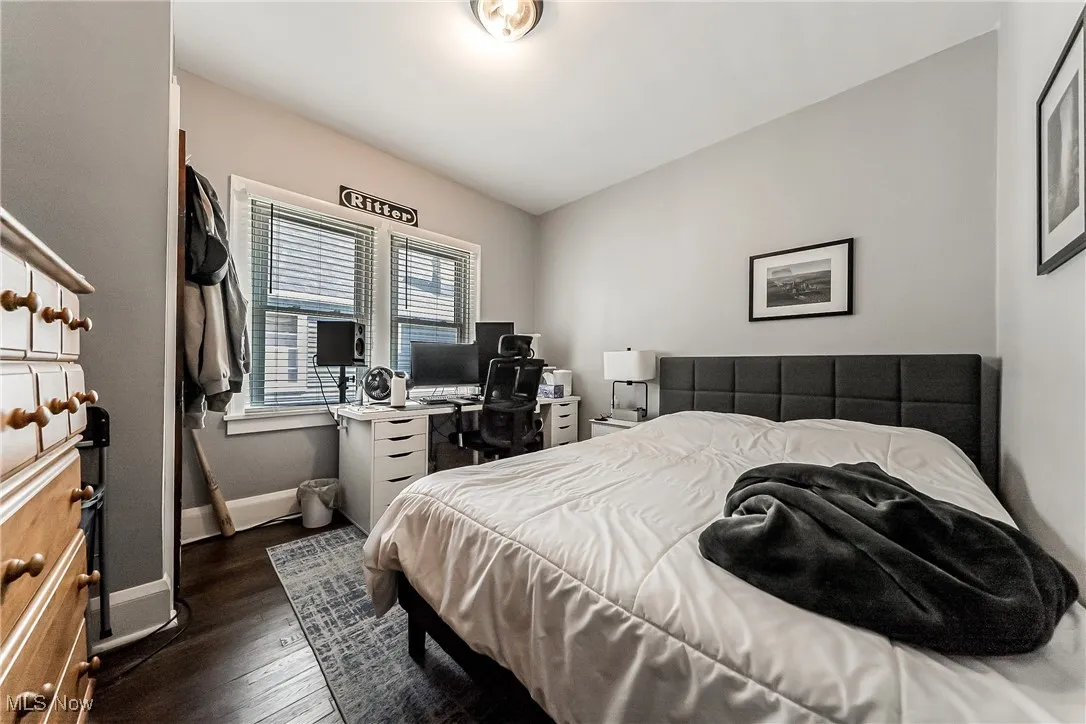 Bedroom with dark wood finished floors and a desk