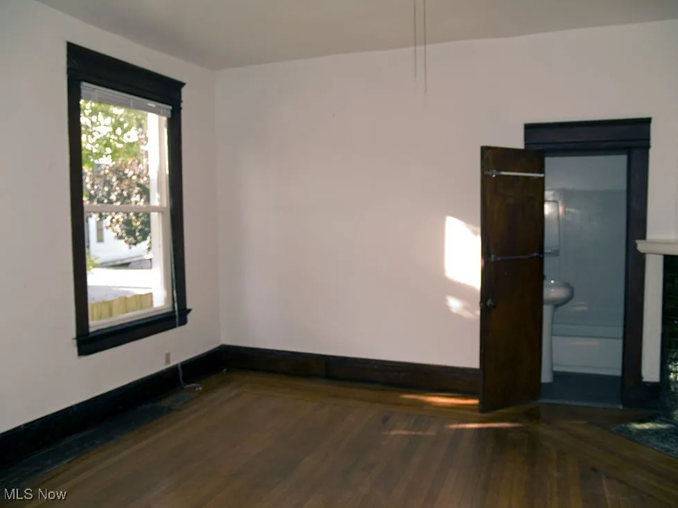 Spare room featuring hardwood / wood-style flooring and baseboards