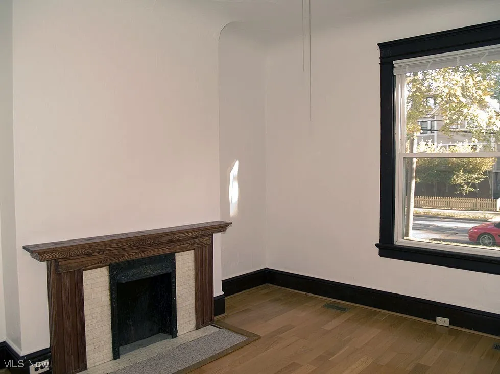 Unfurnished living room with wood finished floors and a fireplace