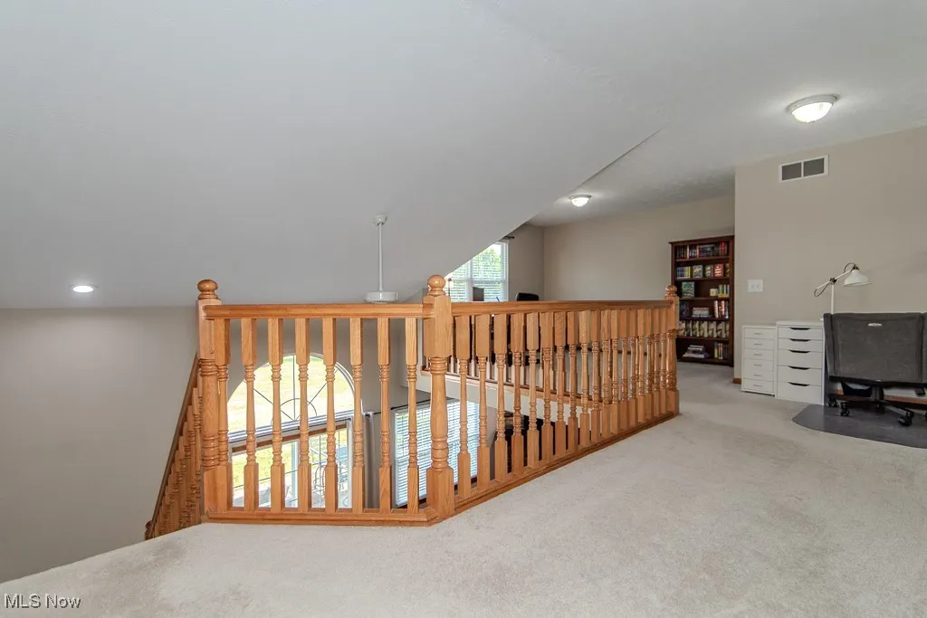 Hall featuring carpet floors and an upstairs landing