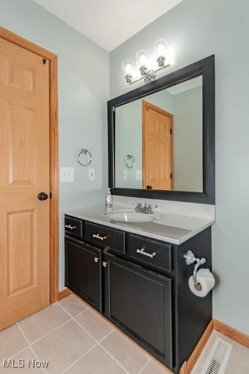Bathroom with tile patterned floors and vanity
