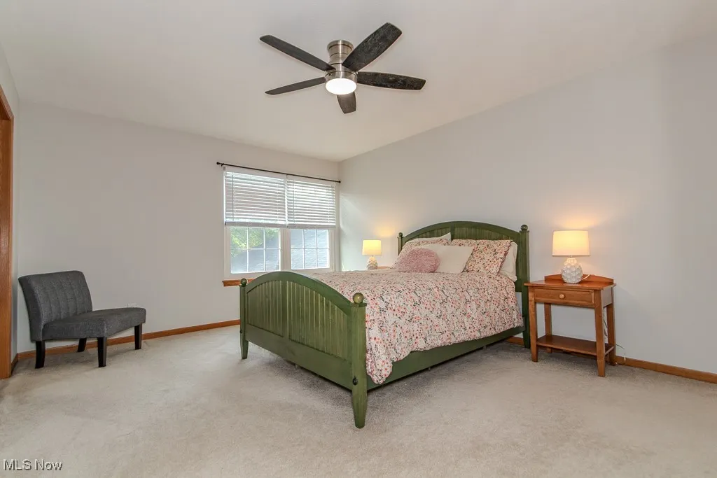 Bedroom with light carpet and a ceiling fan