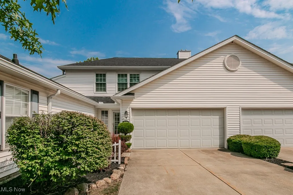 Traditional-style home featuring driveway, an attached garage, and a chimney