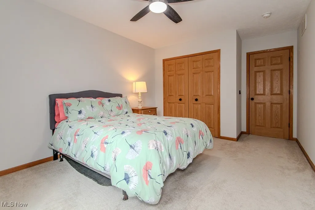 Bedroom with a closet, carpet flooring, and ceiling fan