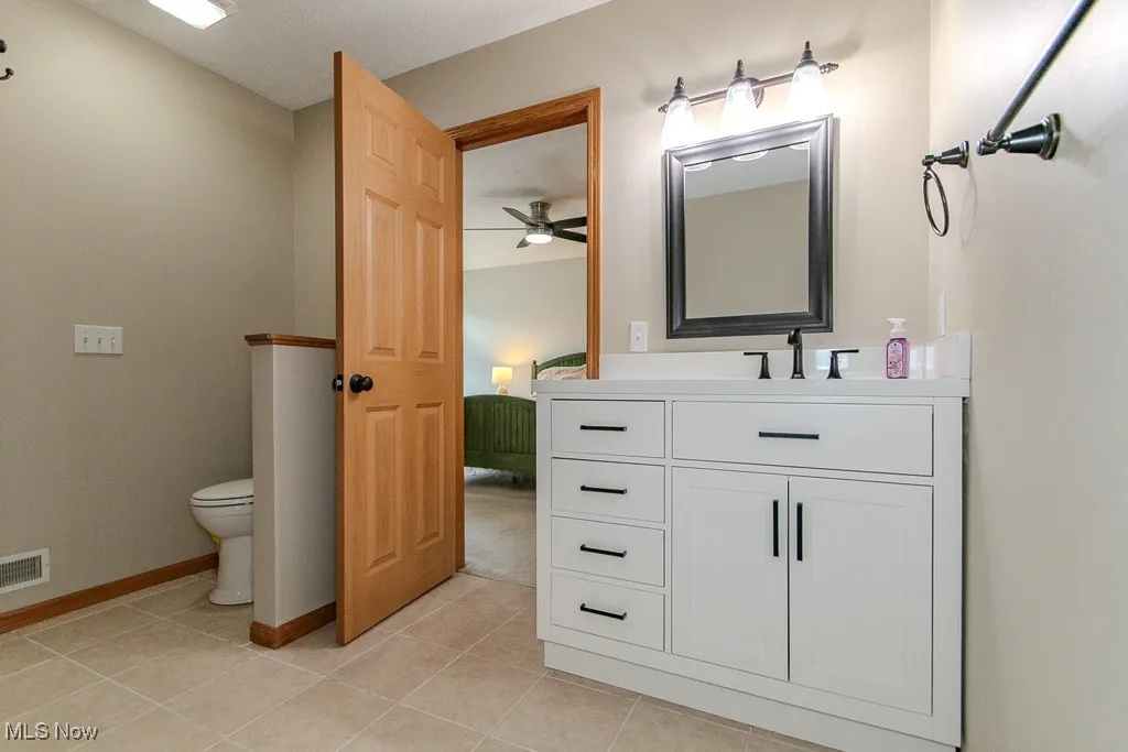 Bathroom featuring vanity, tile patterned flooring, and a ceiling fan
