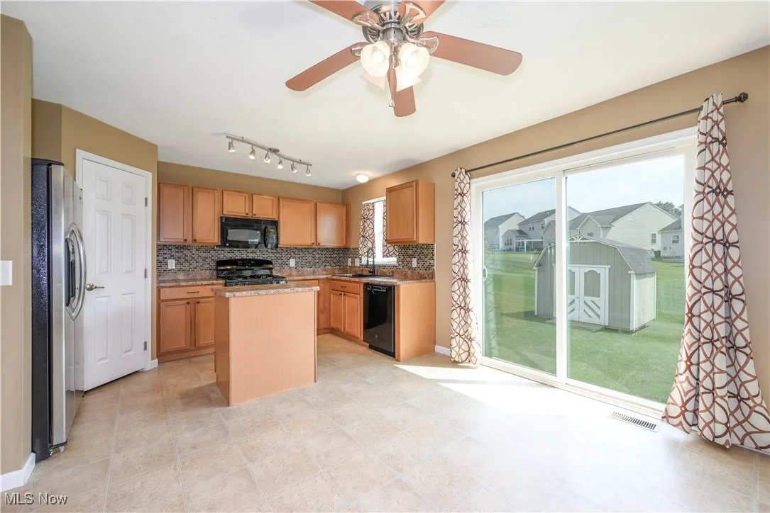 Kitchen with island, black appliances and pantry