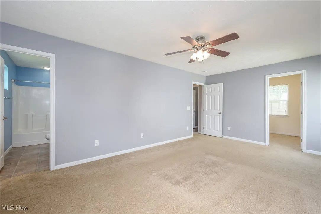 Primary bedroom with view of ensuite bathroom and walk-in closet