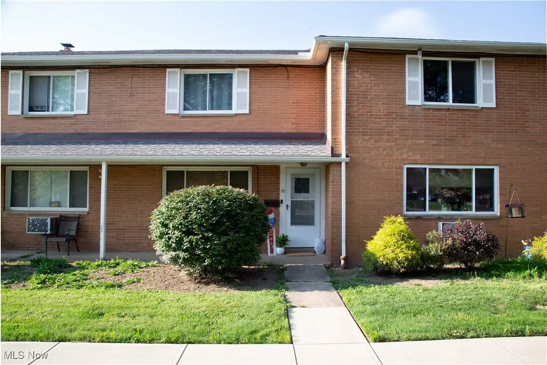 Traditional-style home with brick siding and a front yard
