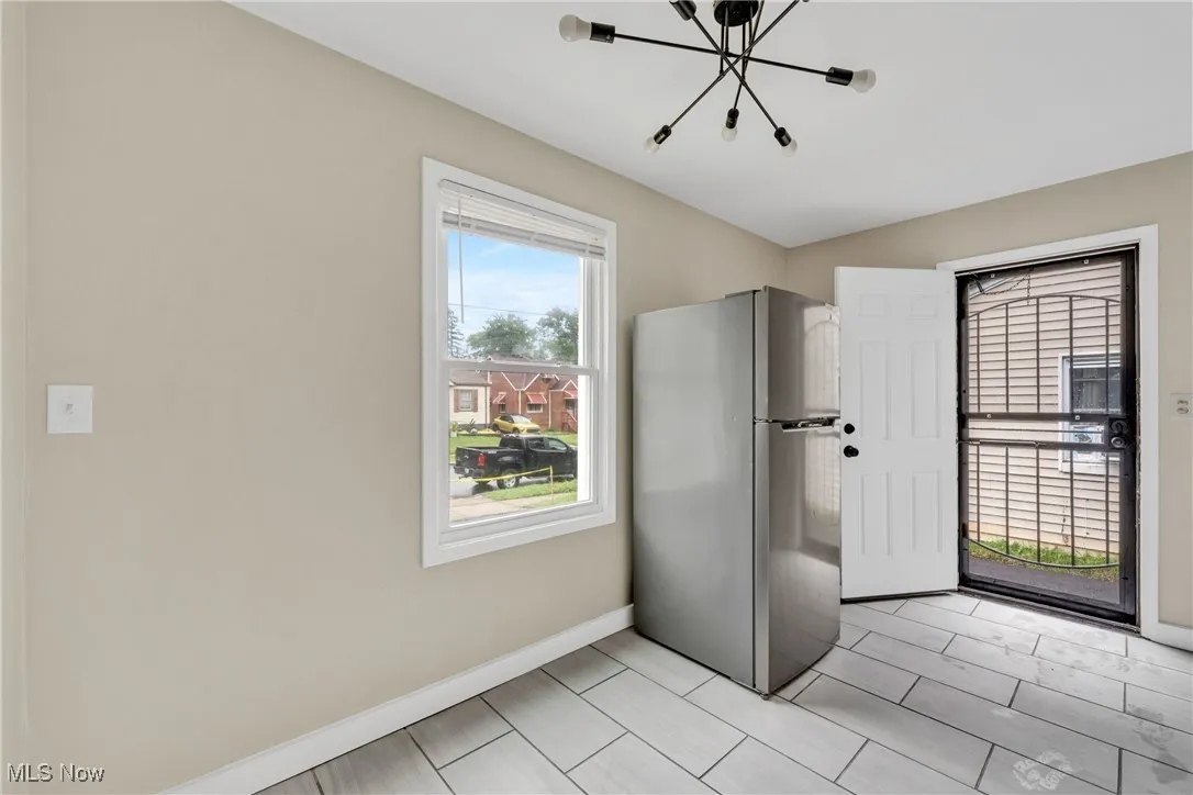 Kitchen with freestanding refrigerator and a chandelier