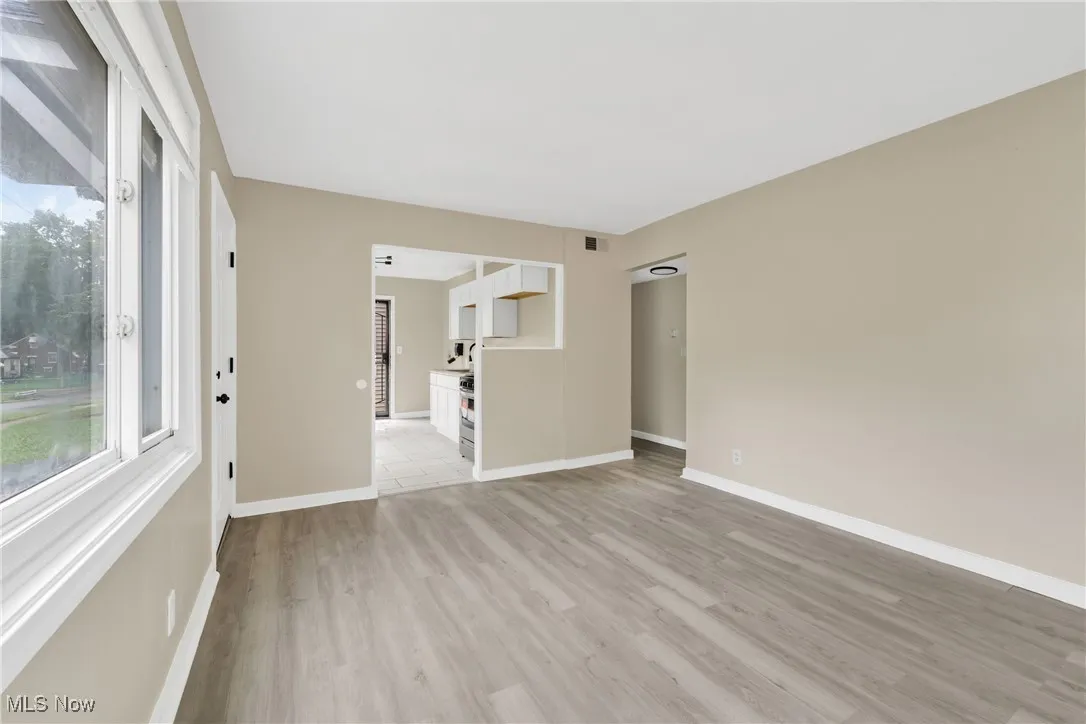 Empty room with light wood-style flooring and baseboards