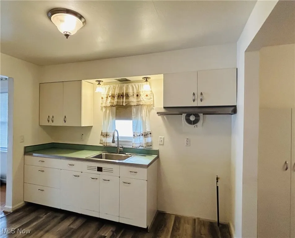 Kitchen featuring a sink and white cabinetry
