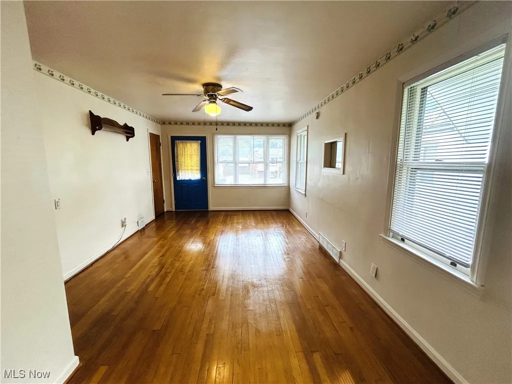Living room with wood-type flooring and ceiling fan