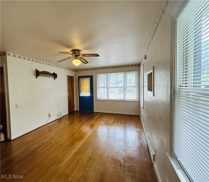 Living room with wood-type flooring and ceiling fan