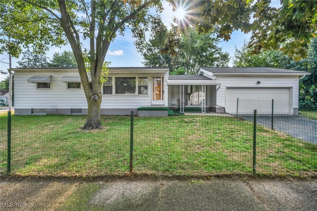 Single story home featuring an attached garage, a porch, and driveway