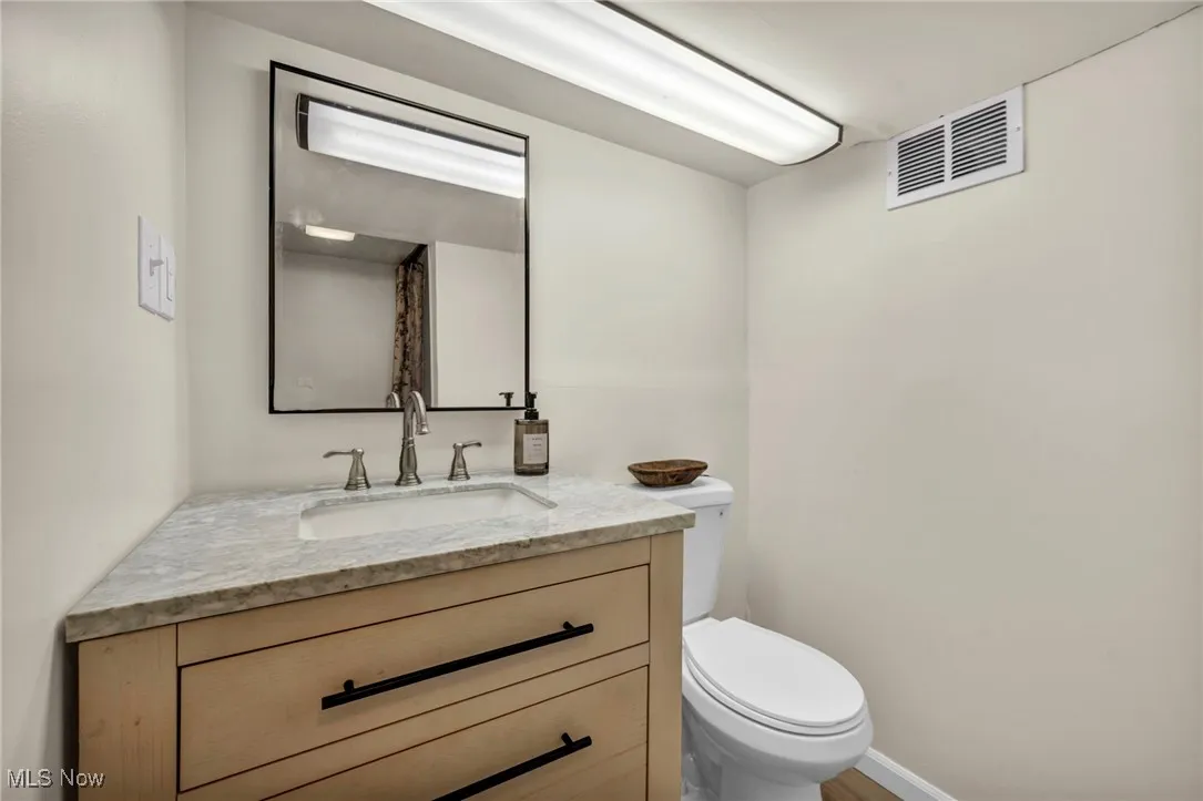 Half bath featuring toilet and vanity