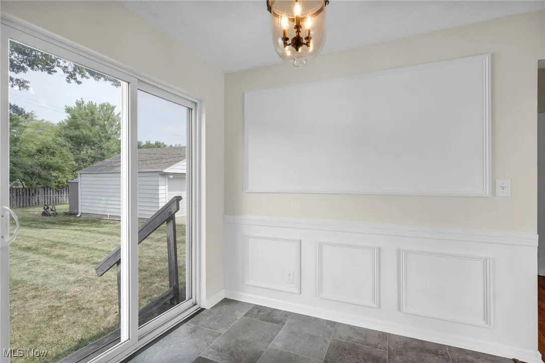 Unfurnished dining area with wainscoting and a decorative wall