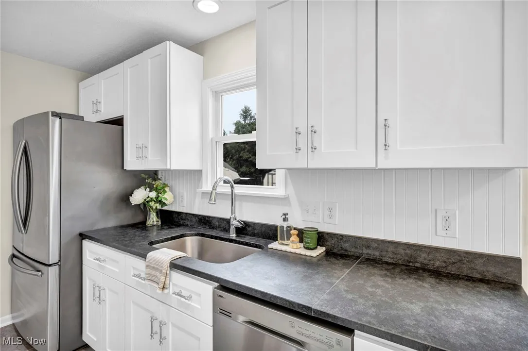 Kitchen featuring dark countertops, white cabinetry, and stainless steel appliances