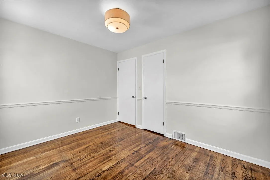 Unfurnished bedroom featuring wood finished floors and baseboards
