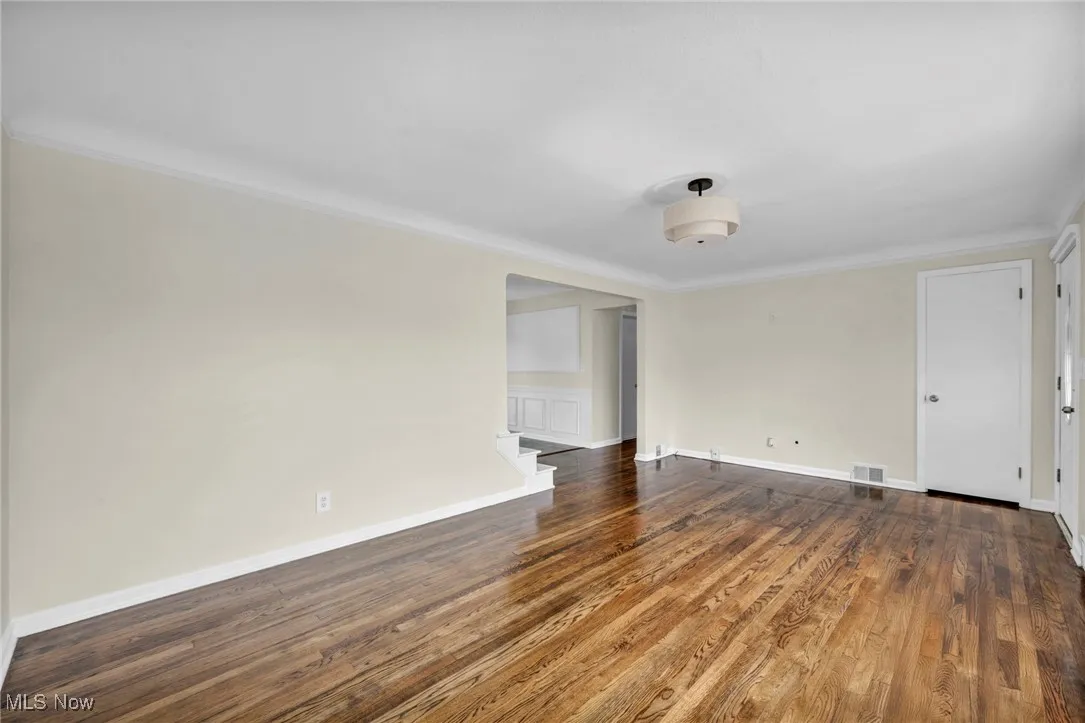 Unfurnished room featuring wood finished floors and crown molding