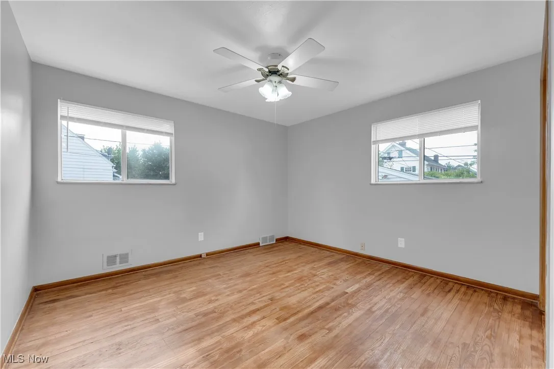 Unfurnished room with healthy amount of natural light, light wood-type flooring, and a ceiling fan