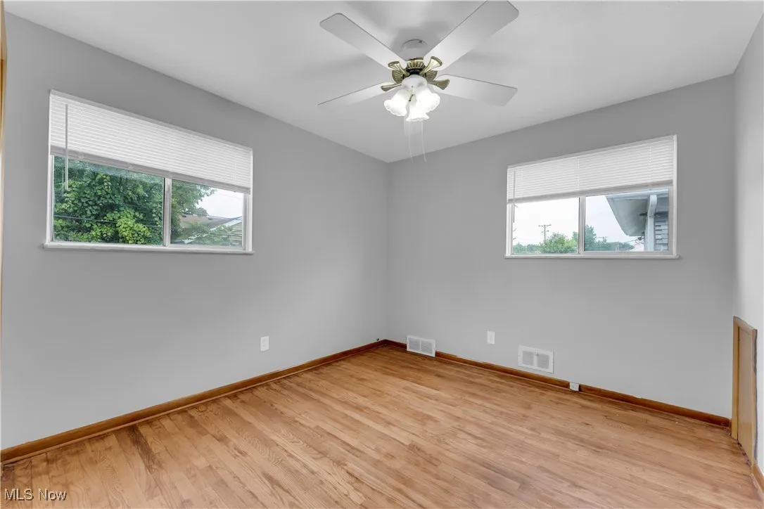 Empty room with light wood finished floors and ceiling fan