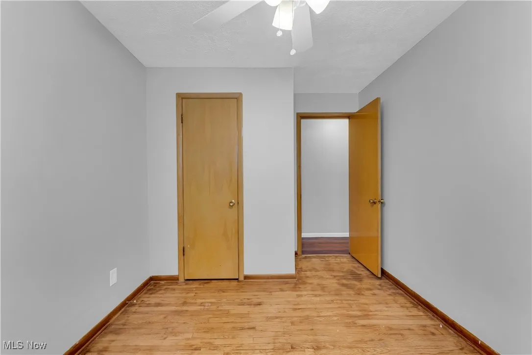 Unfurnished bedroom featuring light wood-type flooring, a textured ceiling, and a ceiling fan