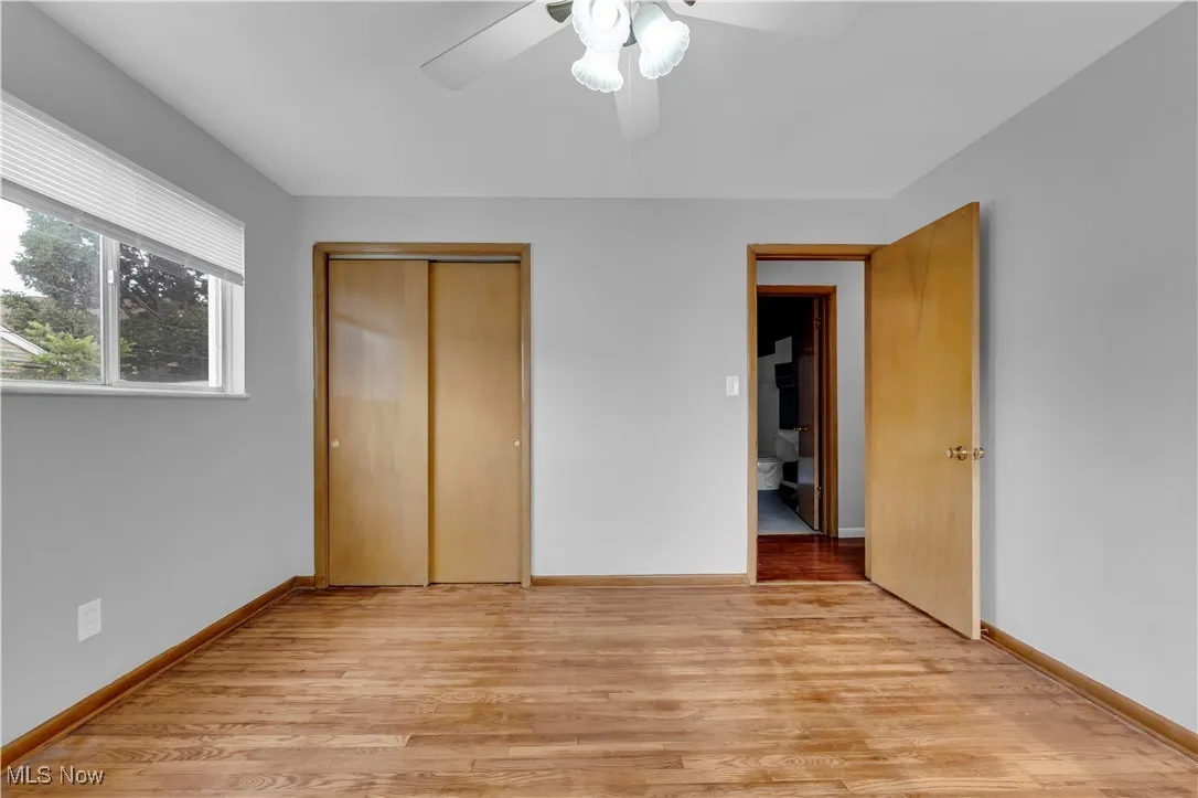 Unfurnished bedroom featuring light wood finished floors, a closet, and ceiling fan