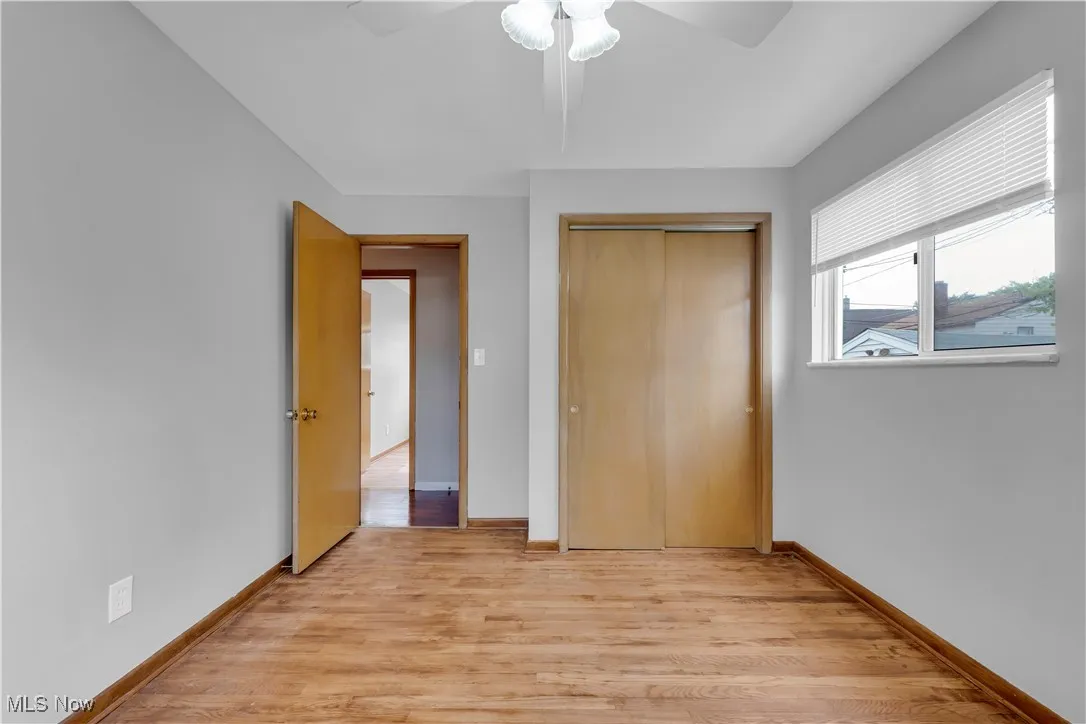 Unfurnished bedroom featuring light wood finished floors, a closet, and a ceiling fan