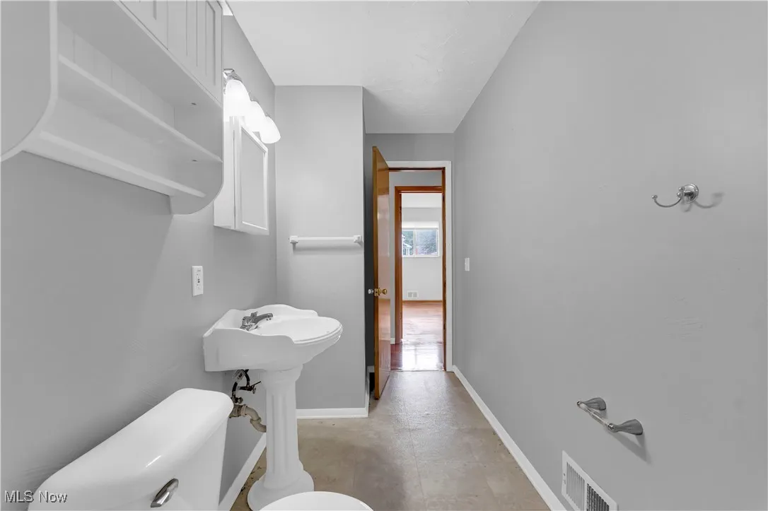 Half bathroom featuring toilet and baseboards