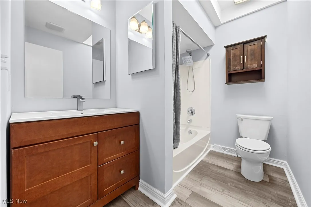 Full bathroom featuring wood finished floors, vanity, and shower / bathtub combination