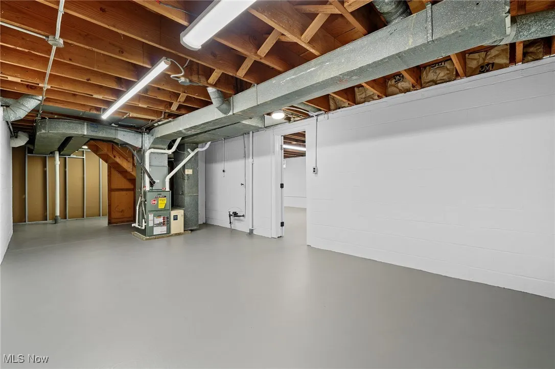 Unfinished below grade area featuring heating unit