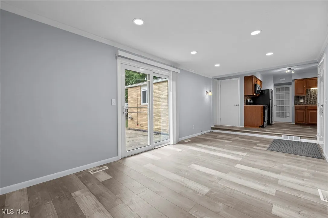 Unfurnished living room with crown molding, light wood-style floors, and recessed lighting