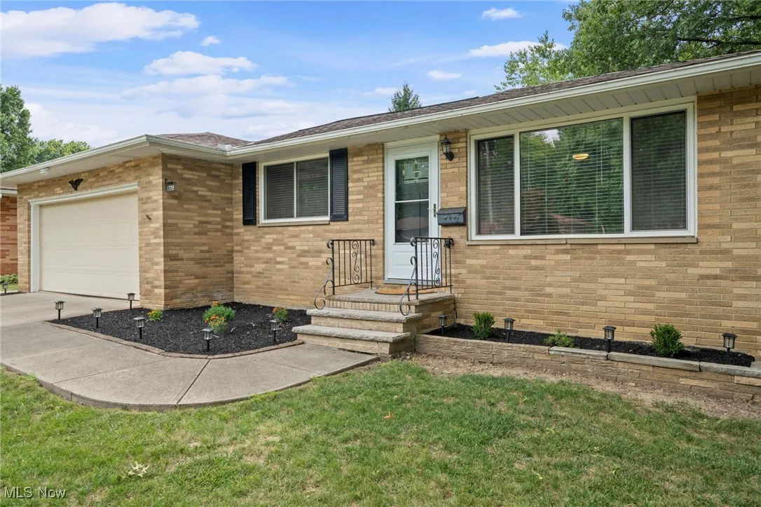 Ranch-style house featuring brick siding, an attached garage, concrete driveway, and a front lawn