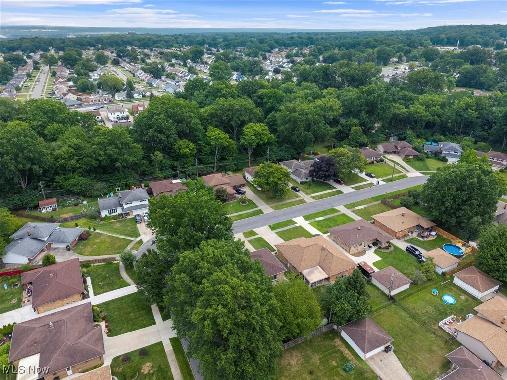Aerial view of property and surrounding area with nearby suburban area
