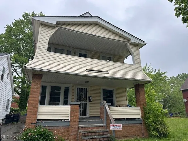 View of front of house featuring covered porch and brick siding