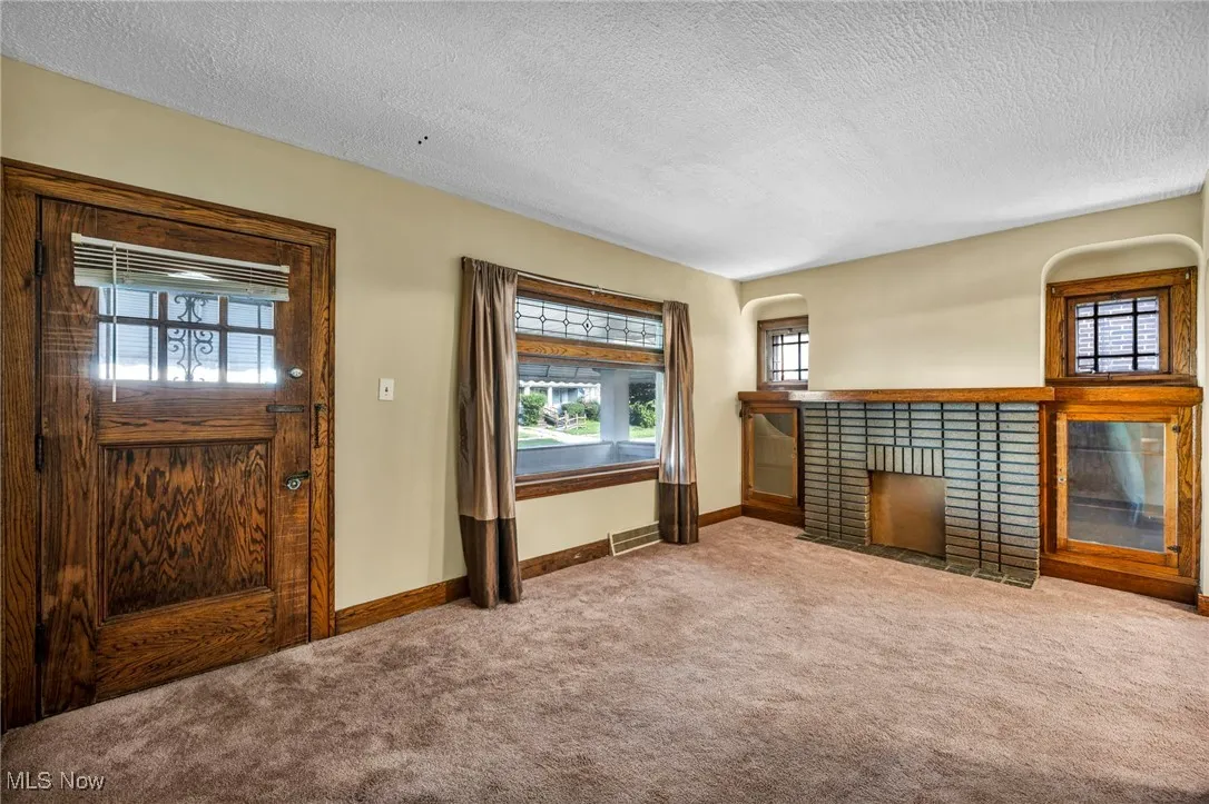 Living room featuring a decorative fireplace and carpet flooring.